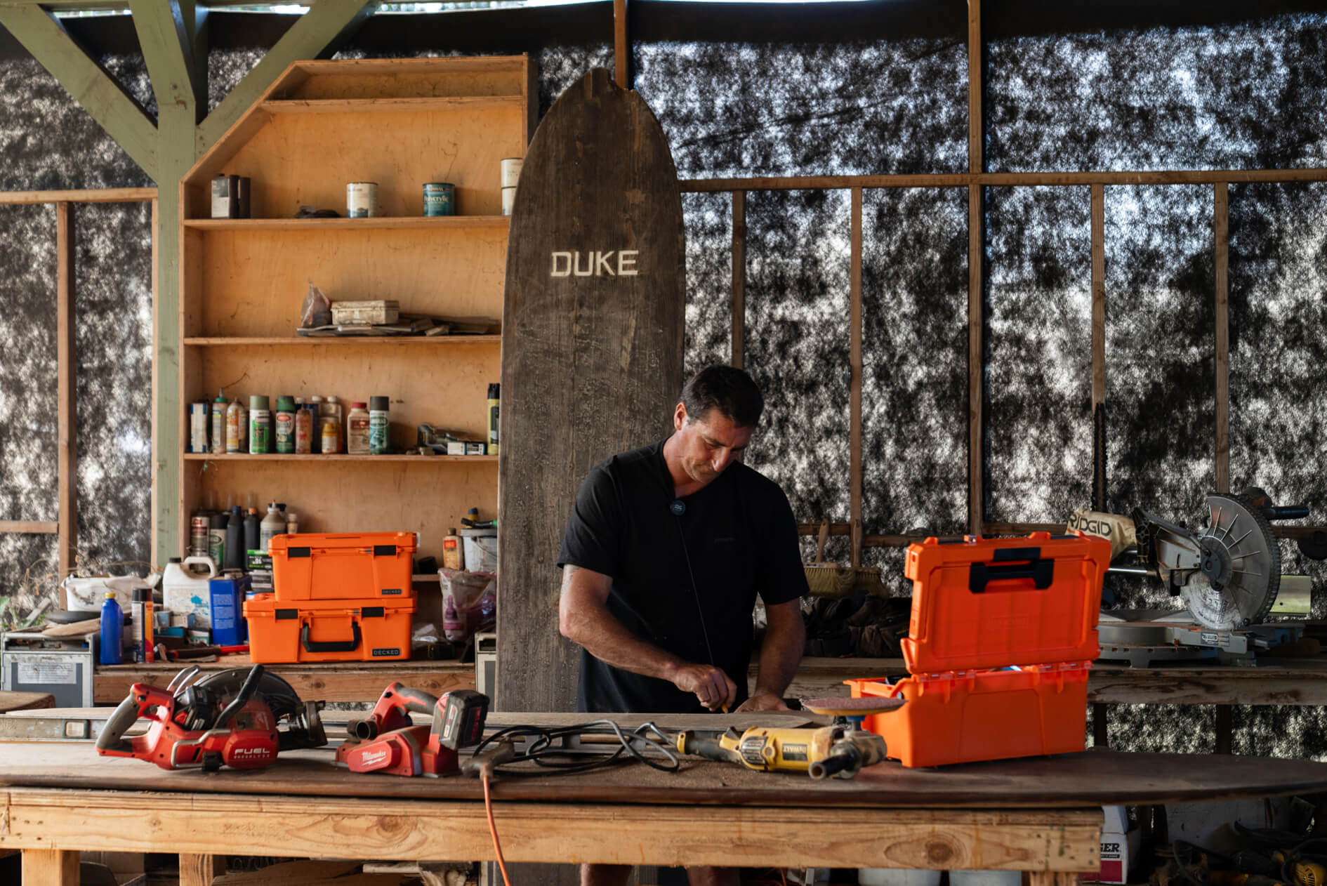 Person working on a project in a workshop with tools and equipment around