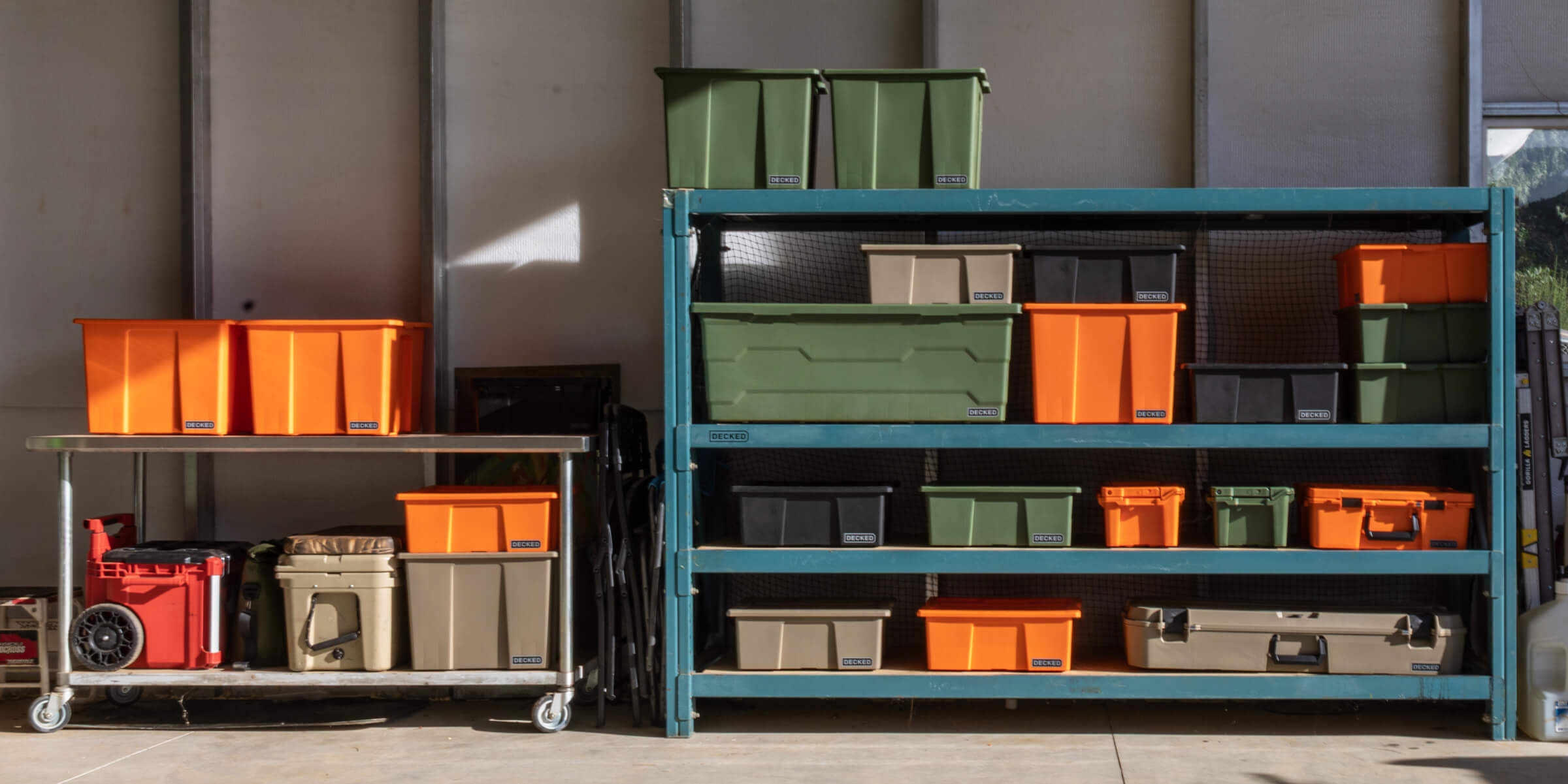 Storage shelves with colorful Payloader bins and protective cases in a garage setting