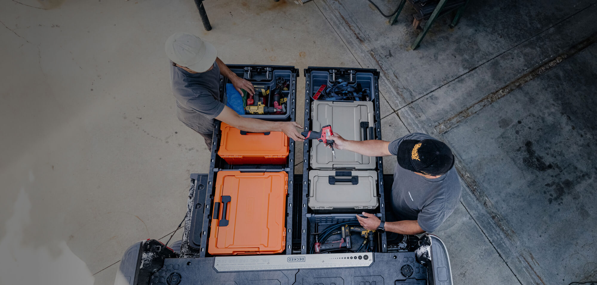 Two mechanics organizing tools in open toolboxes in their DECKED Drawer System.