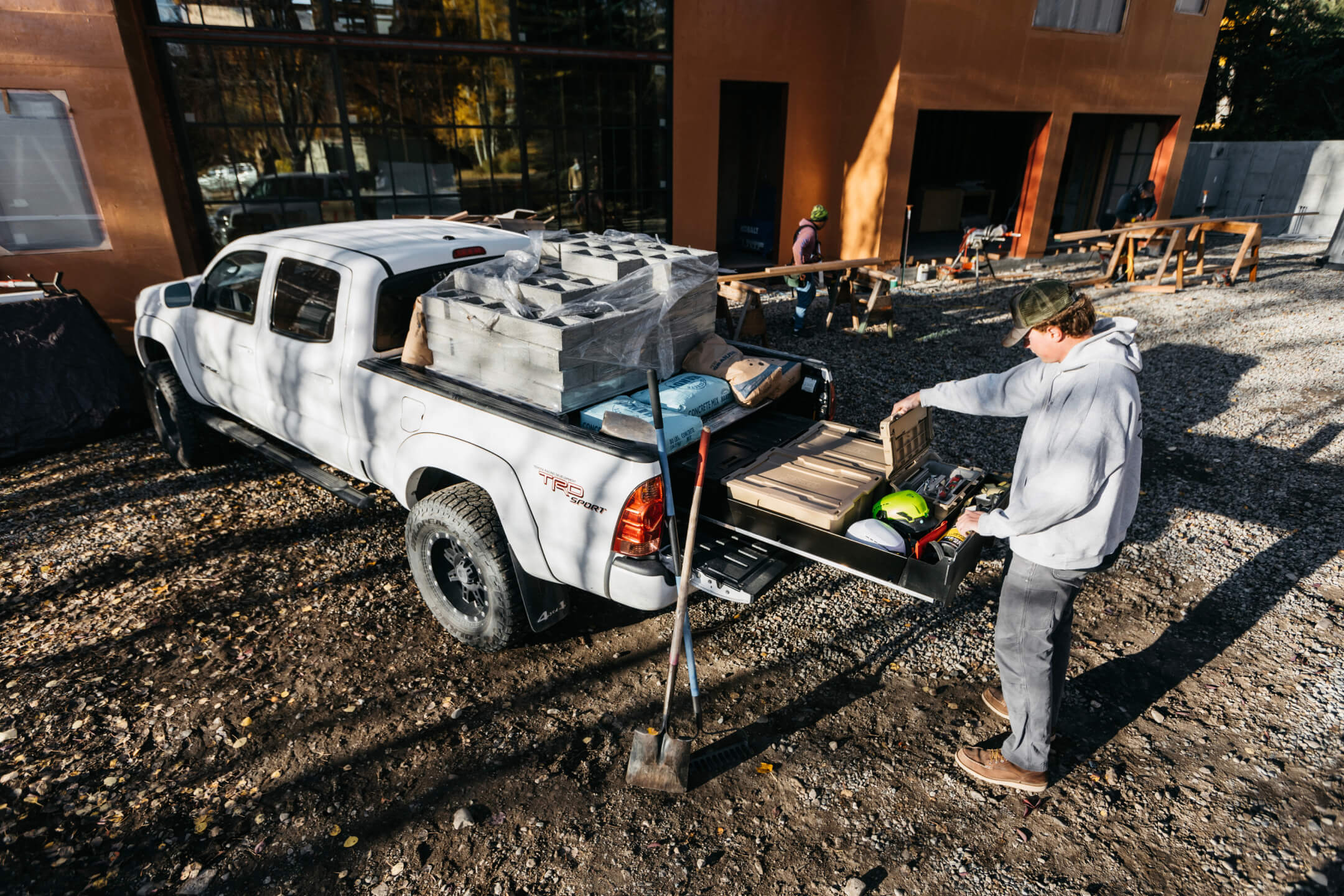Guy standing at back of a truck accessing his tools