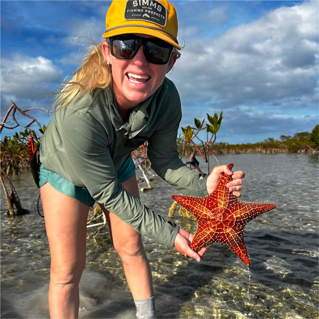 Lacey Kelly holding up an orange starfish