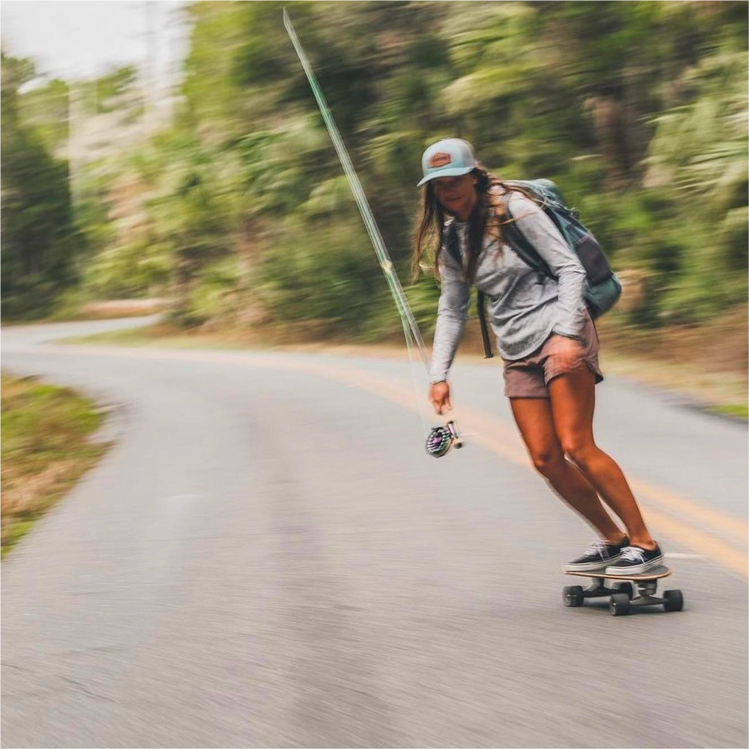 Lacey Kelly on her skateboard, headed to her favorite fly fishing spot.