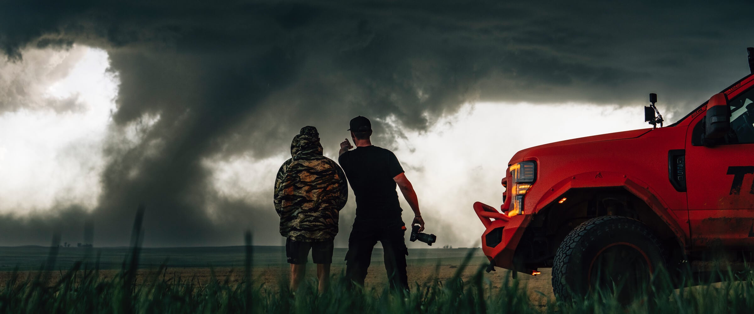 Danny Bolton and Ricky Forbes observing a tornado while standing next to Ricky's storm-chasing truck, Brutus.