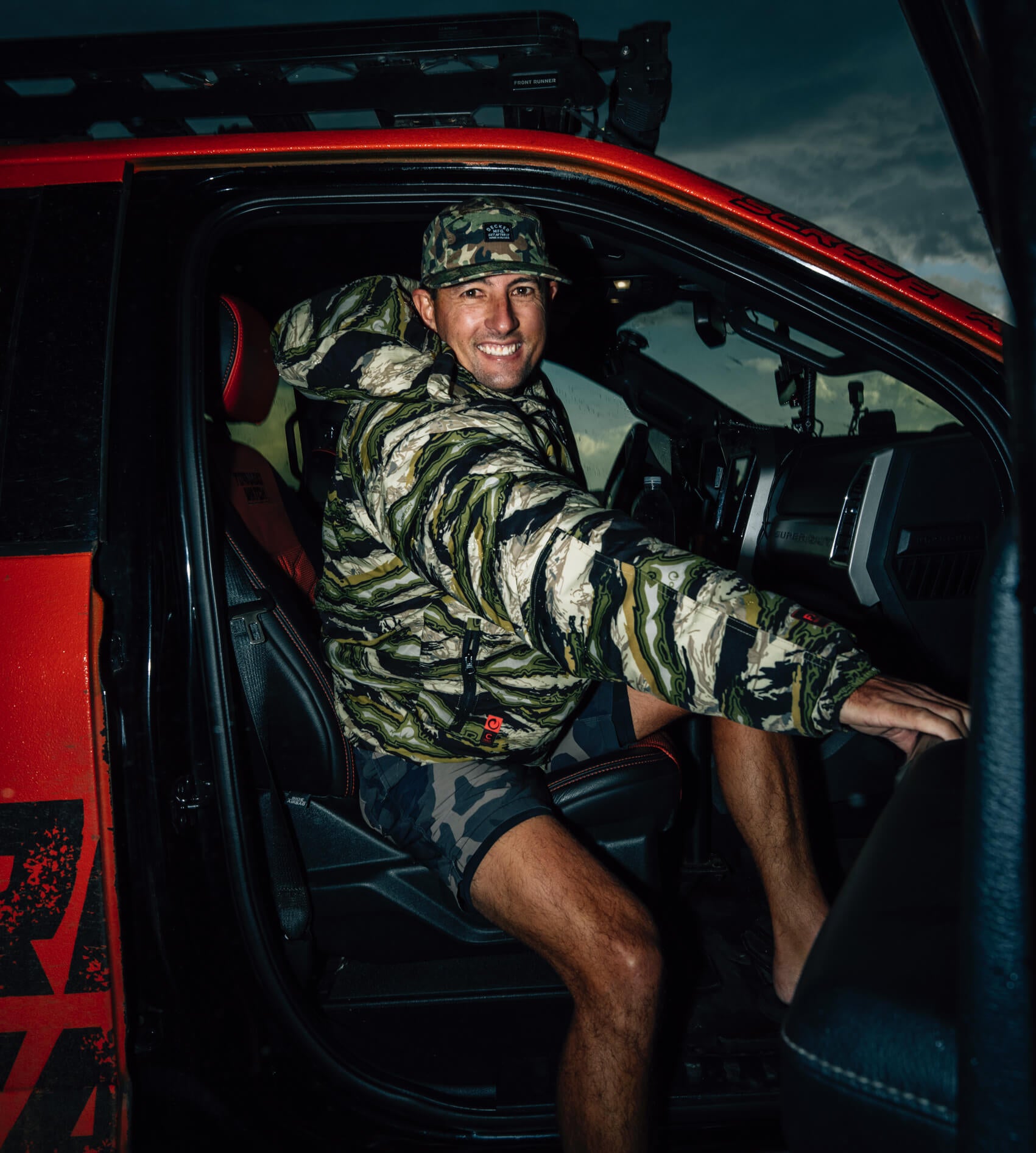Danny Bolton in a camouflage jacket climbing into Ricky's storm-chasing truck, Brutus.