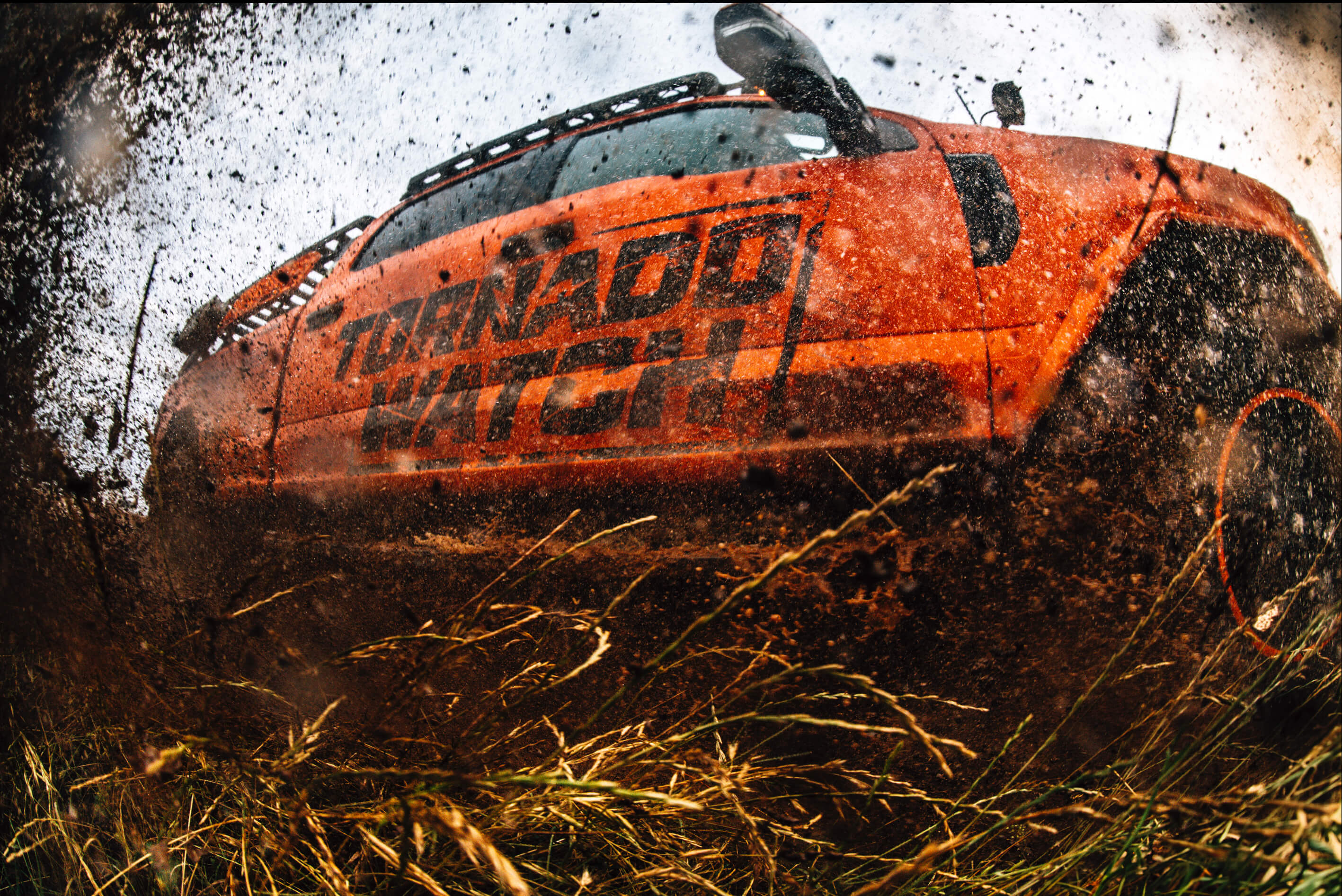 Ricky's mud-splattered off-road, storm-chasing truck called 'Brutus' with 'Tornado Watch' branding on a grassy field.