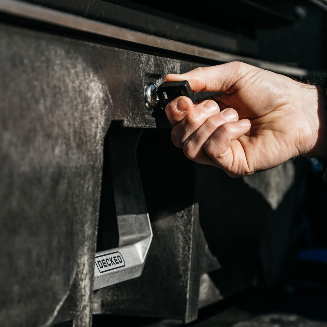 Closeup of a hand opening a drawer lock with a key