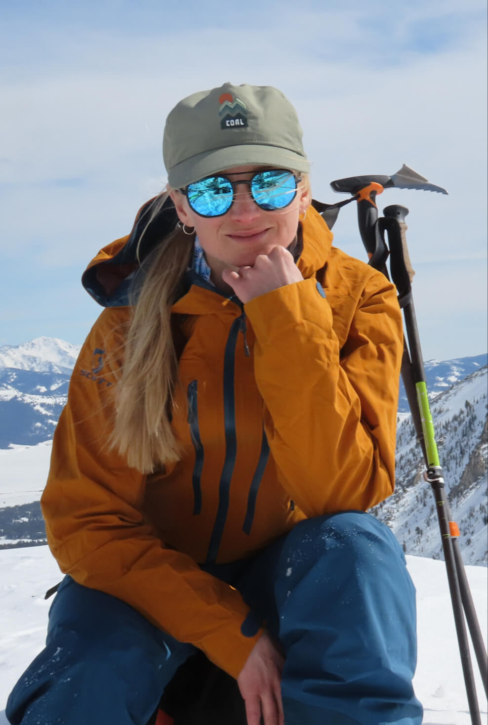 McKenna smiling for the camera with her alpine touring gear behind her.