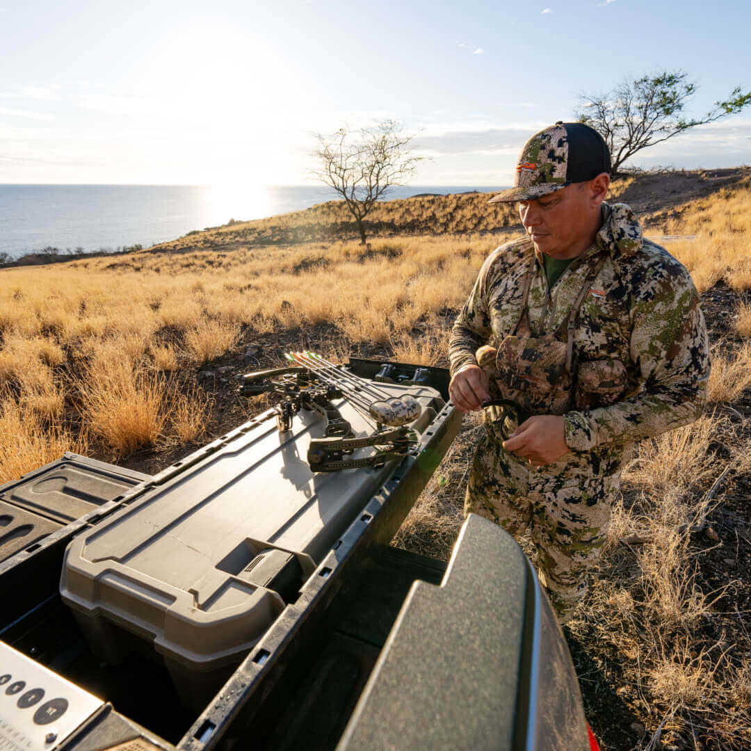 A hunter retrieving his bow from his Desert Tan Honcho