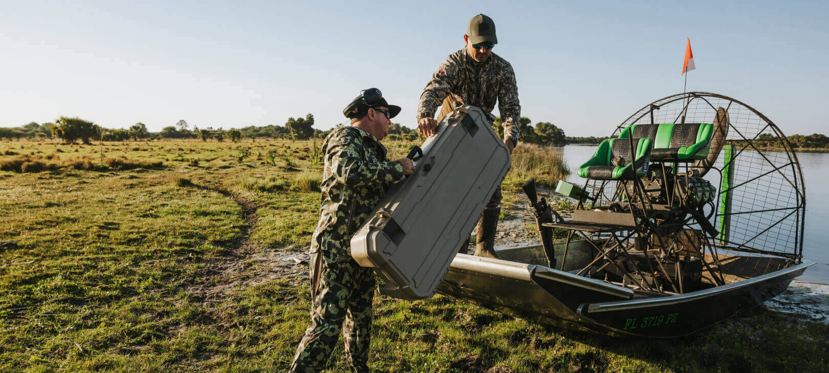 Two men loading a Desert Tan Honcho into their airboat