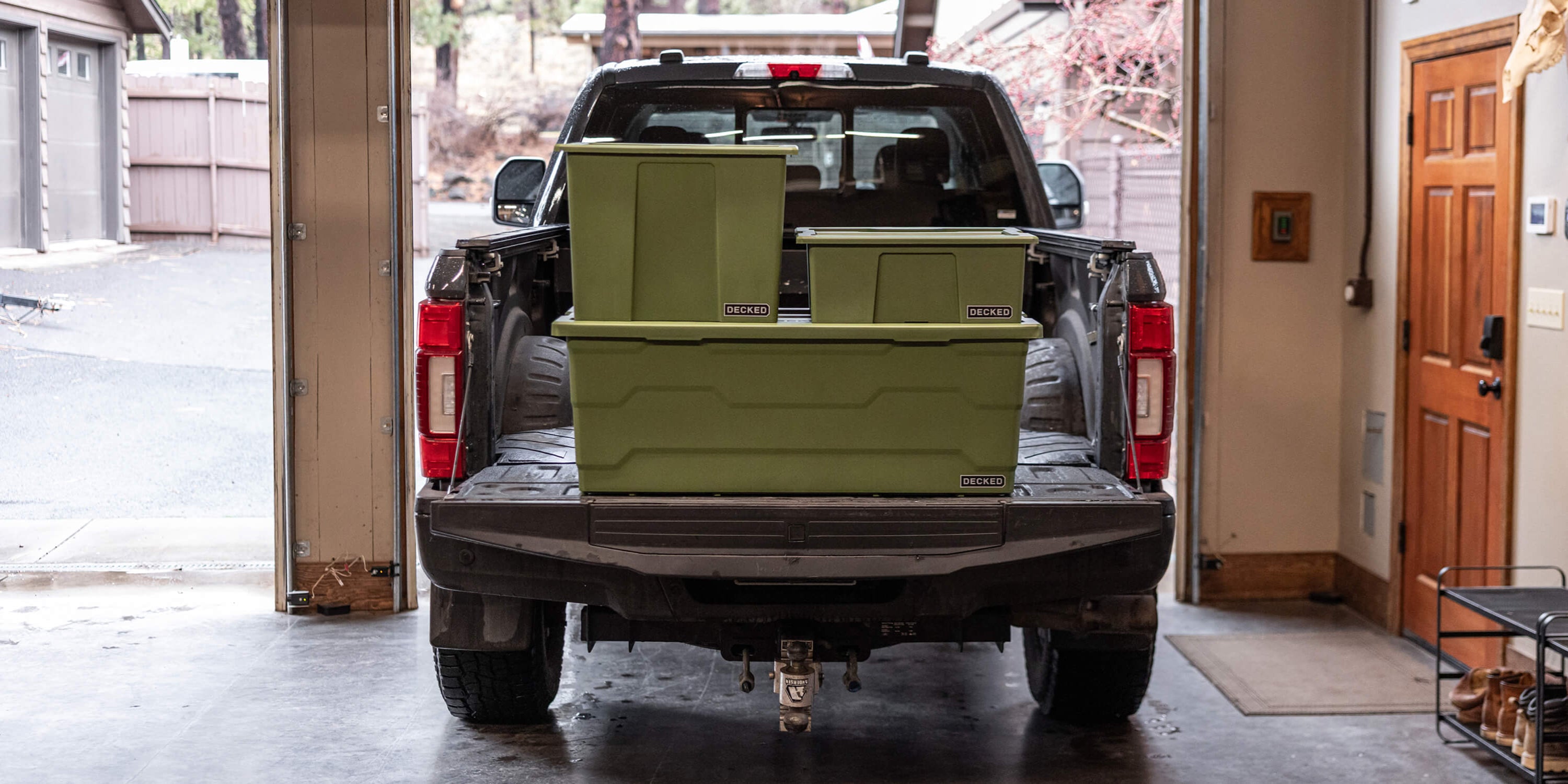 Truck bed with stacked ranger green Payloader storage boxes in a garage setting