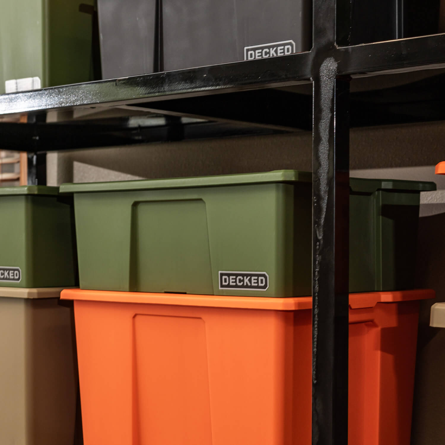 A ranger green Payloader Bin stacked on top of another bin on shelving in a garage.