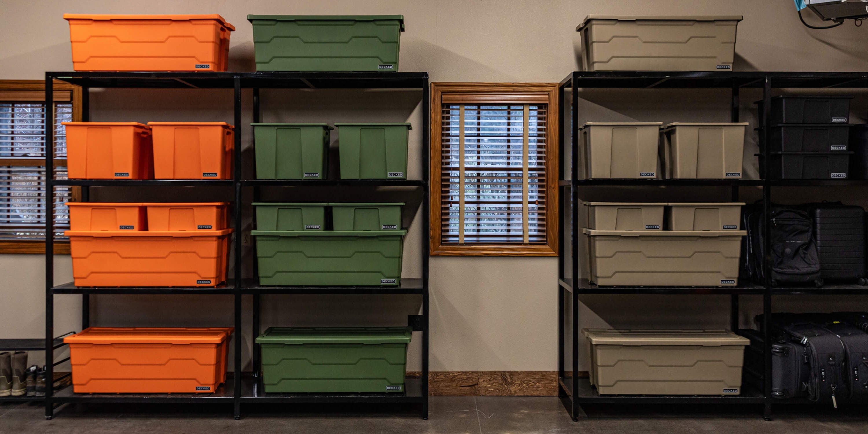 Storage shelves in a garage filled with various sizes of DECKED Payloader Bins, organized by color.