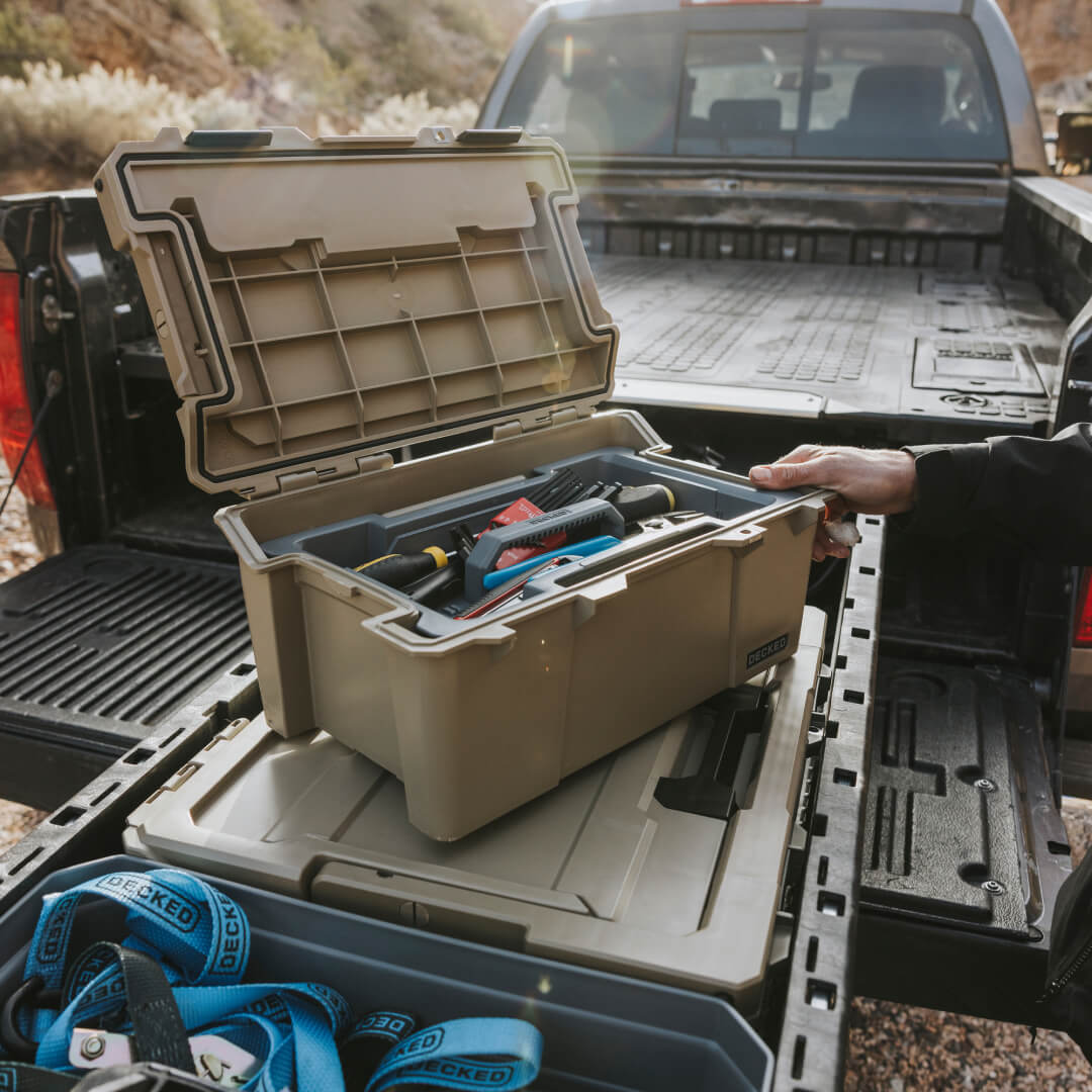 An open Desert Tan Sixer D-co Case with screwdrivers and miscellaneous tools inside.