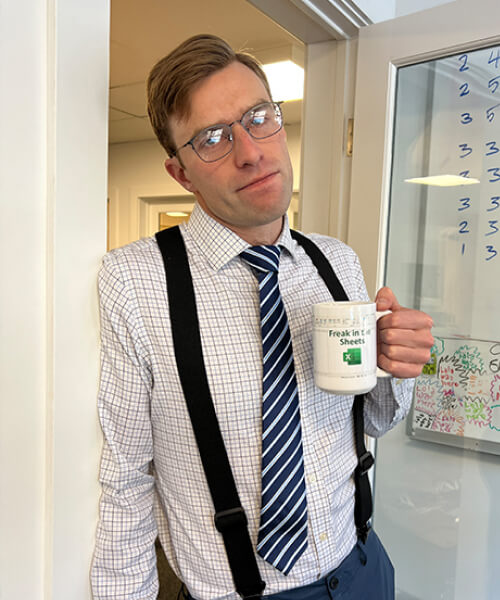 Man in a tie holding a mug of coffee