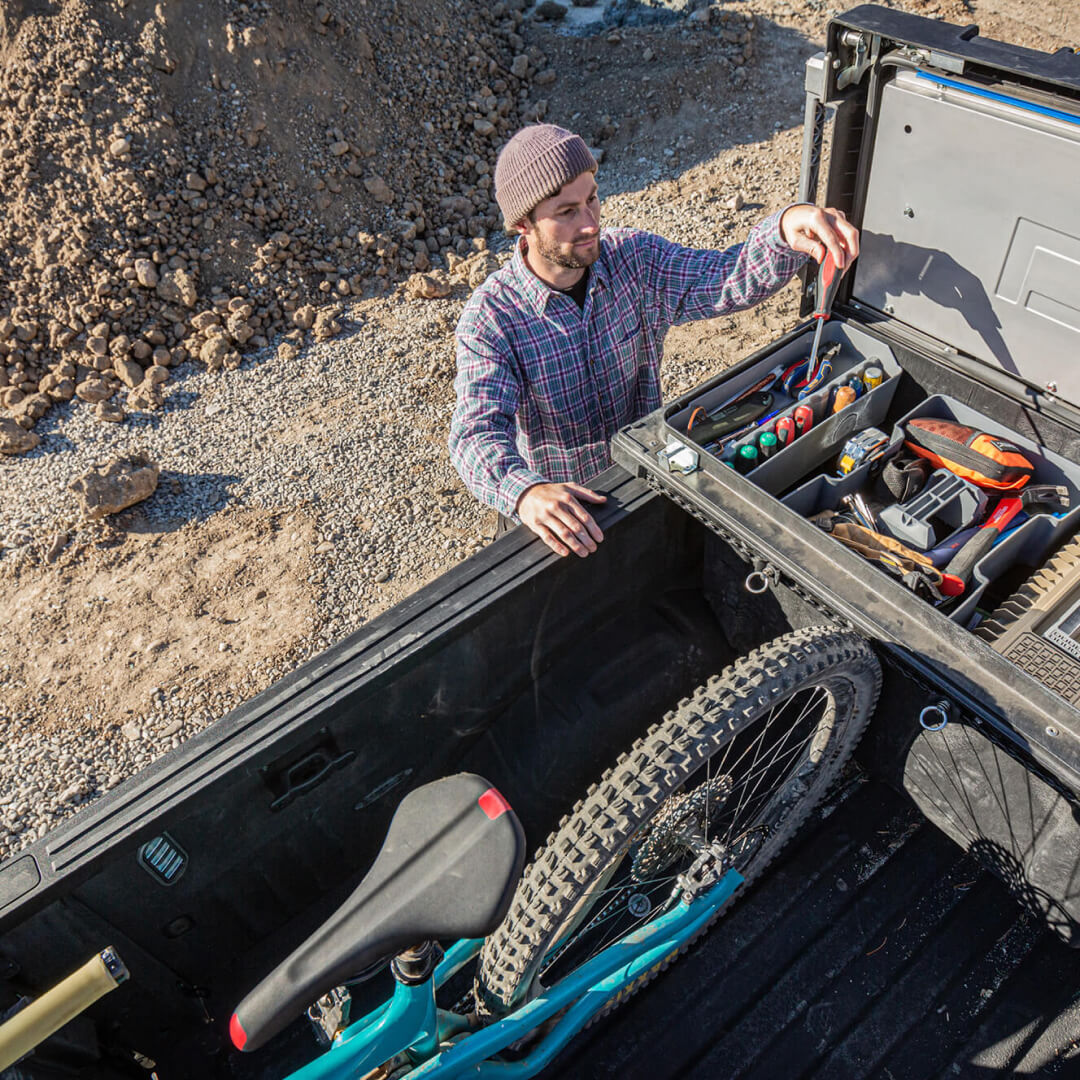 Man grabbing a screw driver from his Super Snack Tray inside a DECKED Tool Box