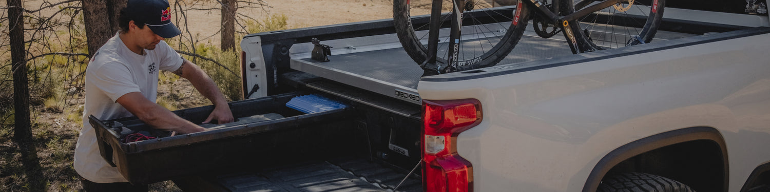 Carson Storch retrieving gear from his DECKED Drawer System. His bike is mounted on his DECKED CargoGlide.