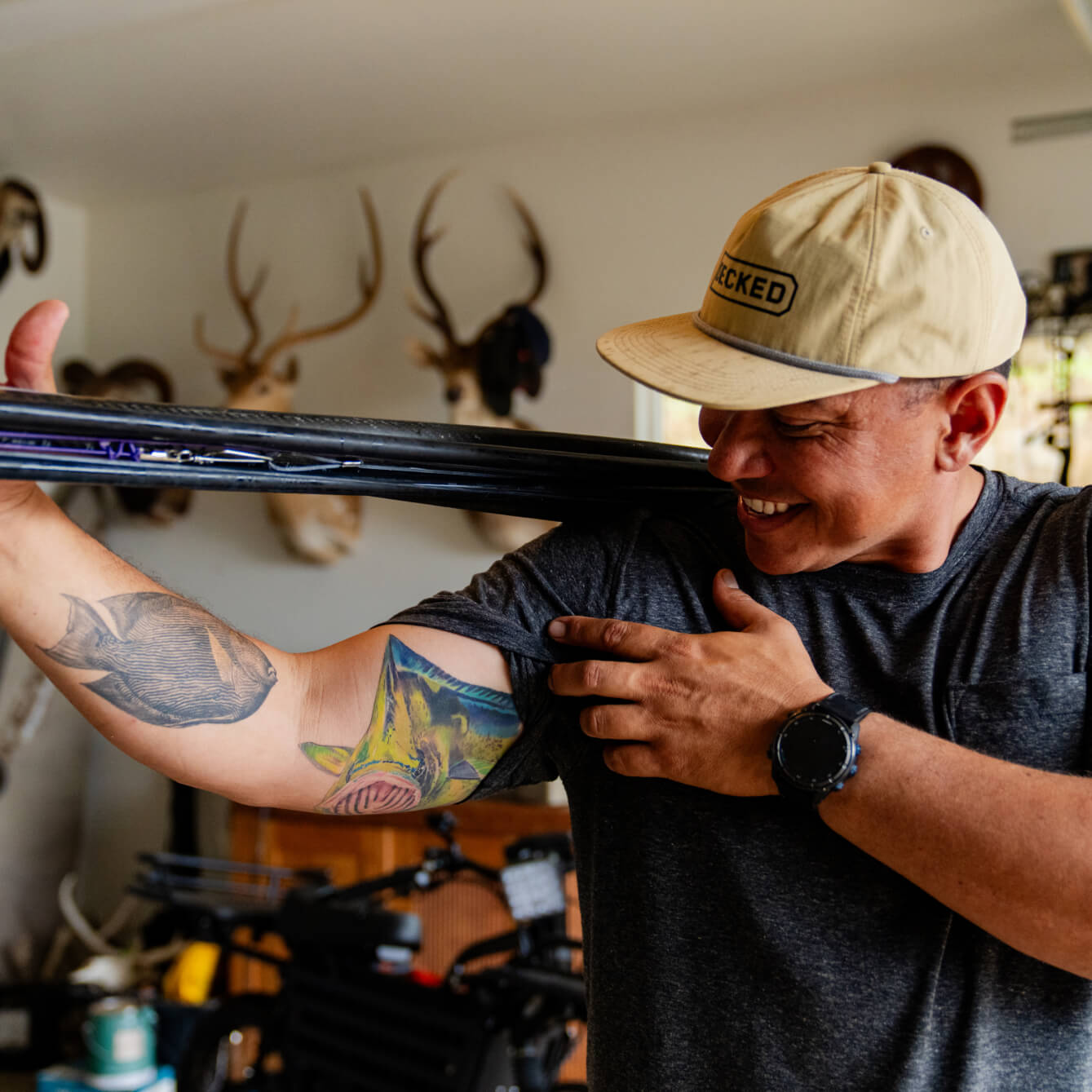 Justin Lee showing off his fish tattoos in his garage.