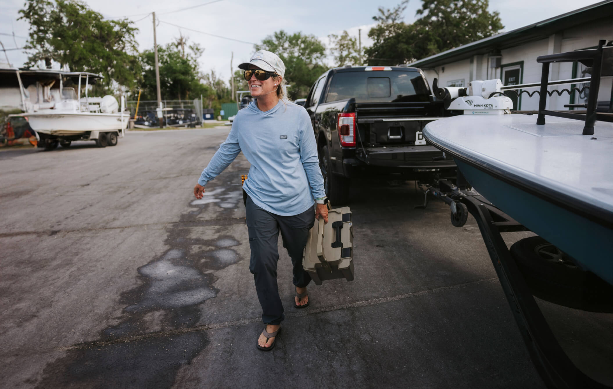 Lacey Kelly carrying a Sixer D-co cases to the boat launch.