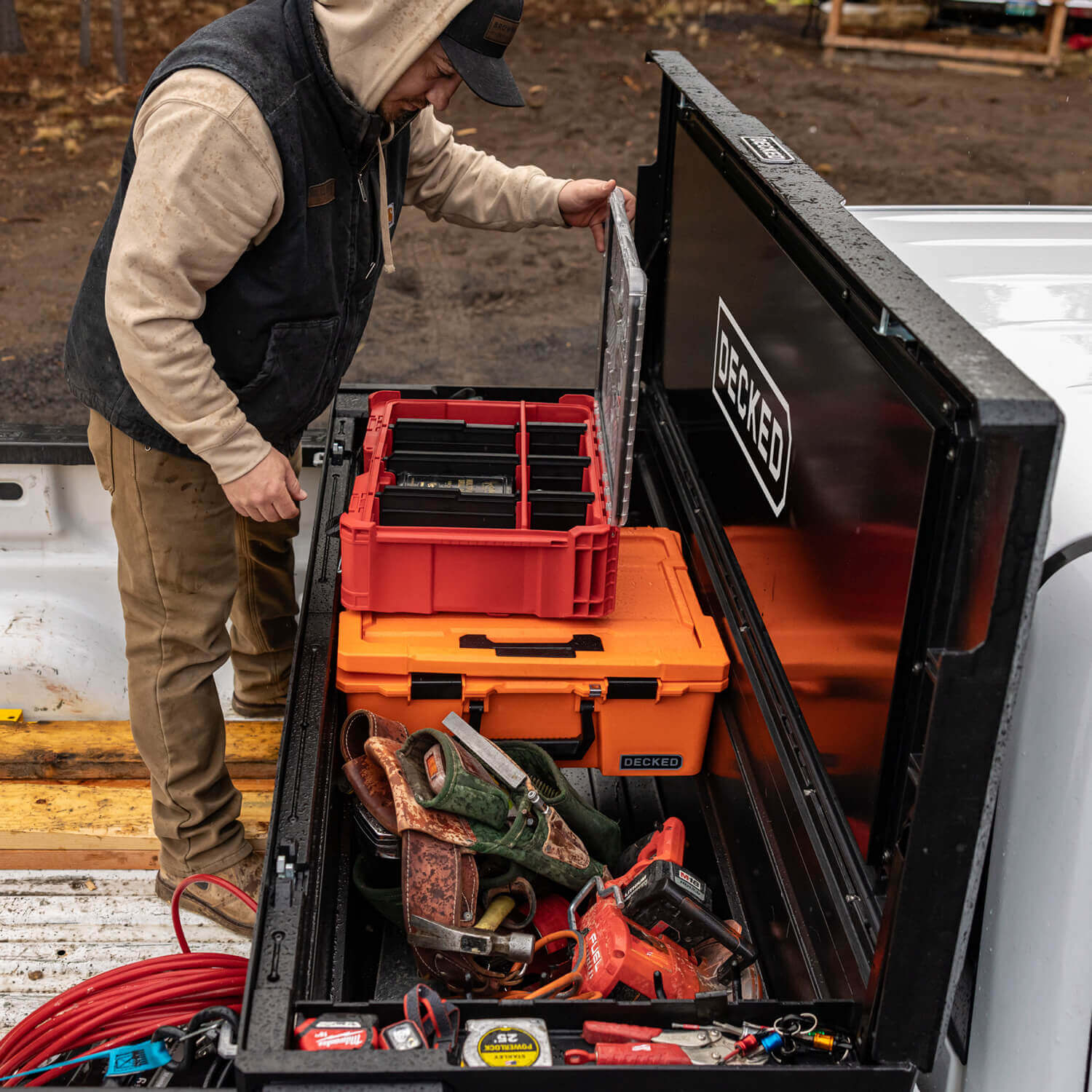 Person organizing tools in a DECKED Tool Box truck bed organizer.