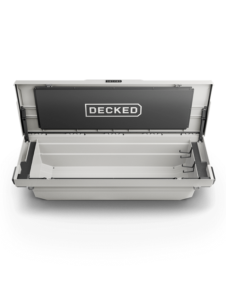 White truck bed tool box with 'DECKED' branding on a brown background