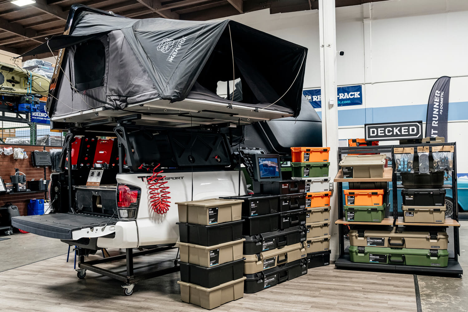 Truck with a rooftop tent and a DECKED Drawer System in a showroom setting