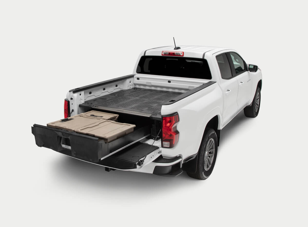 An open drawer system with 'DECKED' d-co cases in the bed of a Ford Truck.