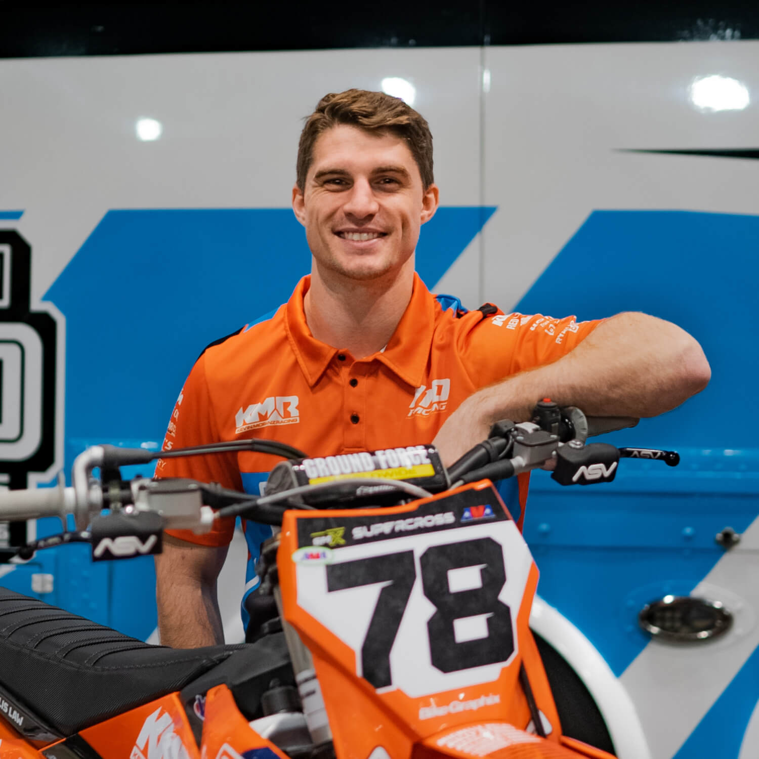 Kevin smiling next to his supercross bike.