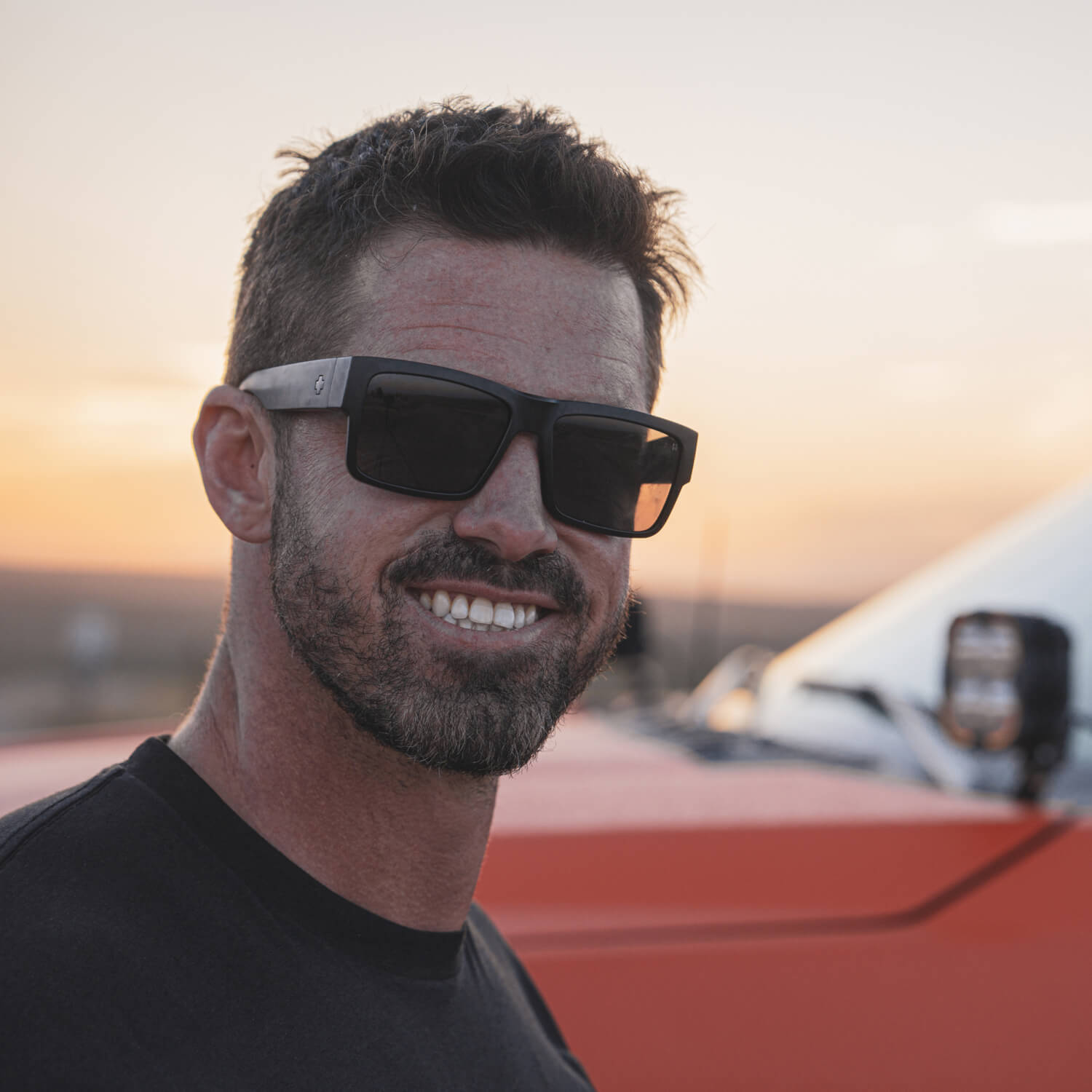 Ricky Forbes in sunglasses with his storm chasing truck behind him.