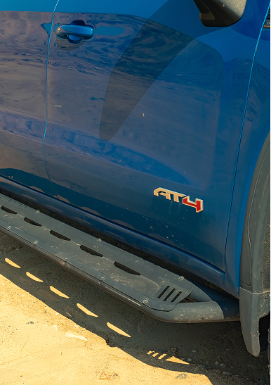 Close-up of the blue passenger side of Thor Rippey’s AT4 truck, showing the running board beneath the doors.