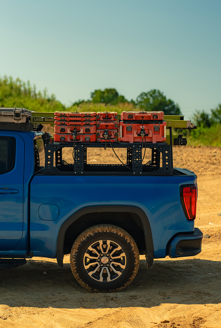 Side view of Thor Rippey’s blue truck with red tool cases and a ladder secured to the rack above the bed.