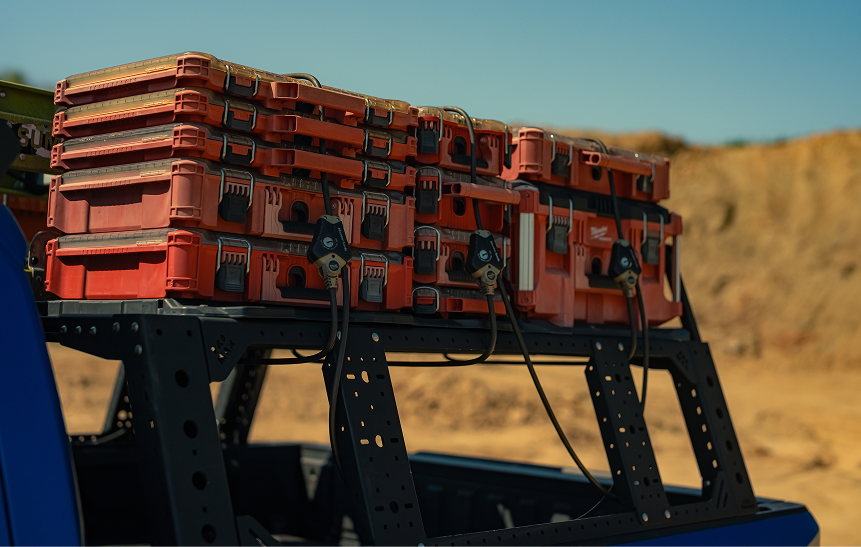 Red Milwaukee tool cases stacked and secured on the bed rack of Thor Rippey’s truck.