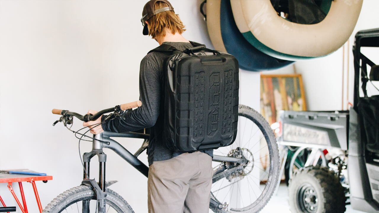 Man holding a bike wearing a d-bag