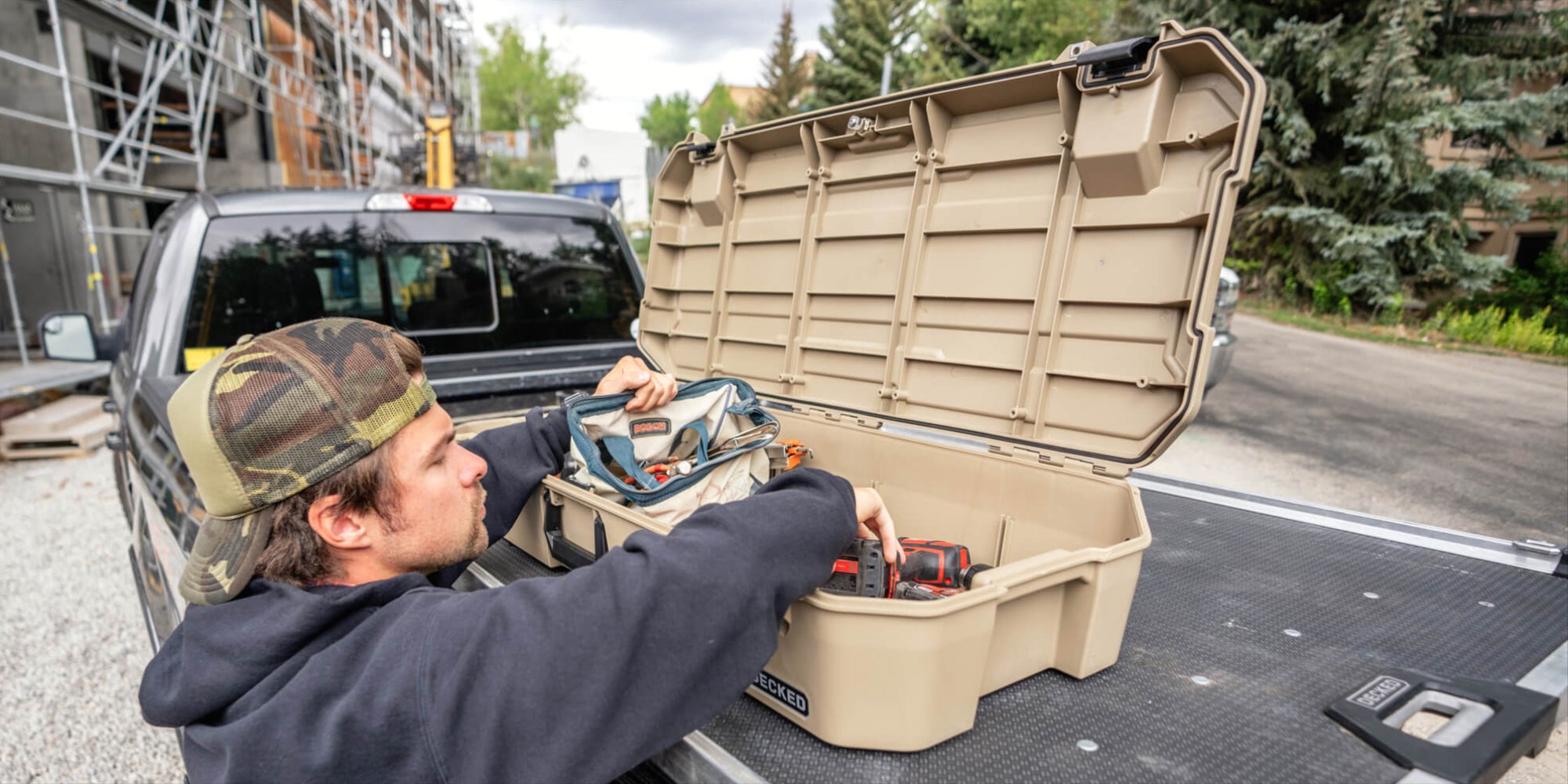 A man grabbing tools out of his DECKED Honcho D-co case mounted to his CargoGlide.