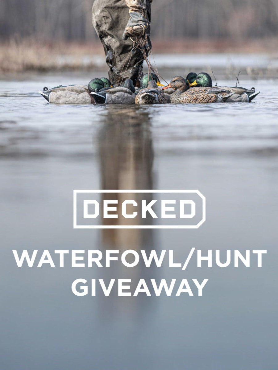 Person in camouflage wading through water with ducks, text 'Decked Waterfowl/Hunt Giveaway' overlay.