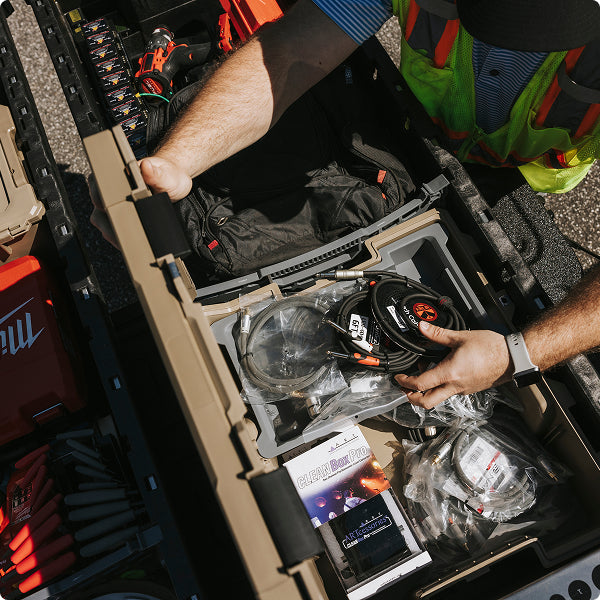 Worker organizing welding cables and equipment in a DECKED case.