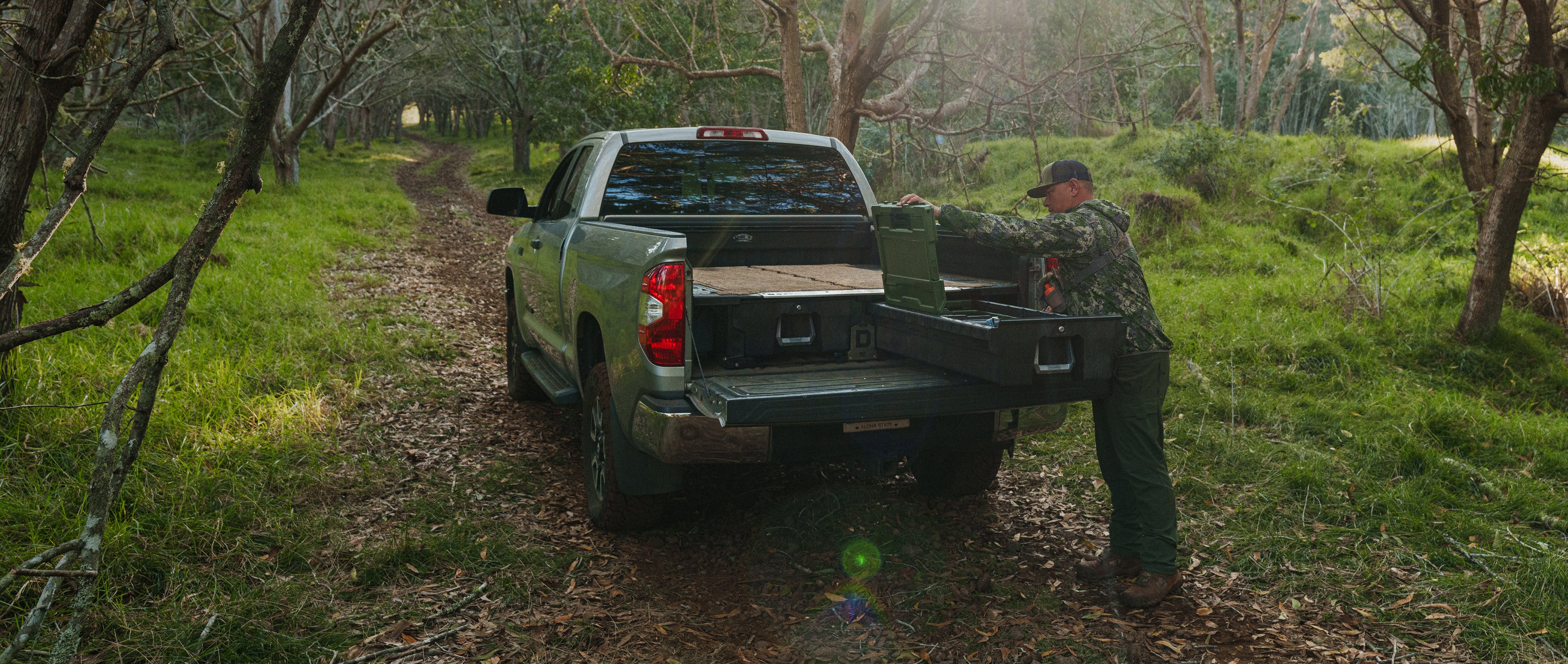Person loading a truck with supplies in a forested area