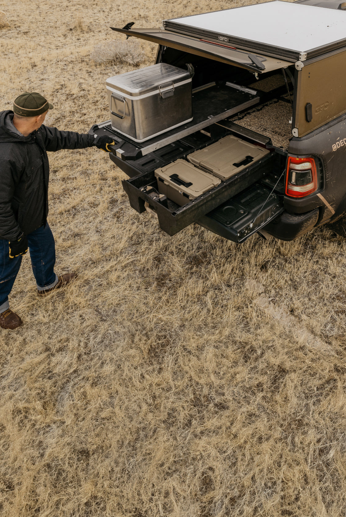 A man extending his CargoGlide on top of a Drawer System out of his DECKED out truck.