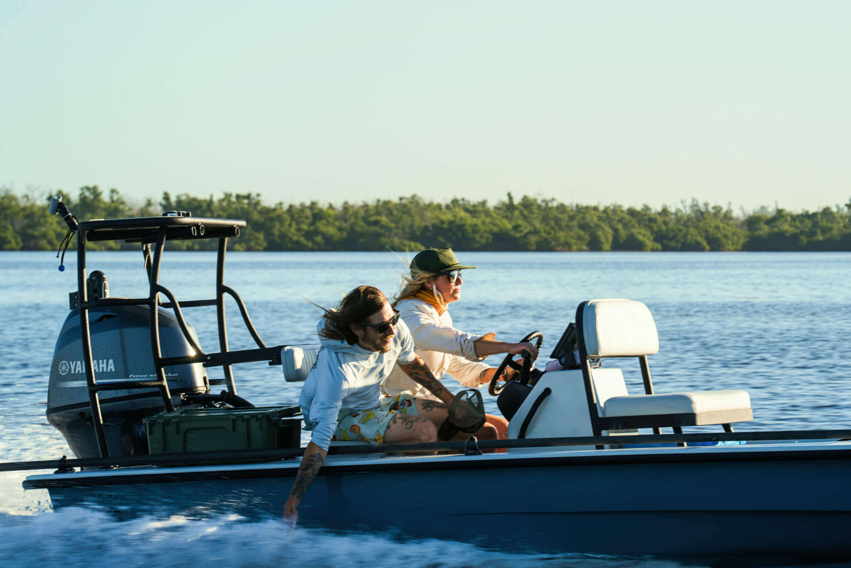 Two people on a boat with a Yamaha motor on a lake