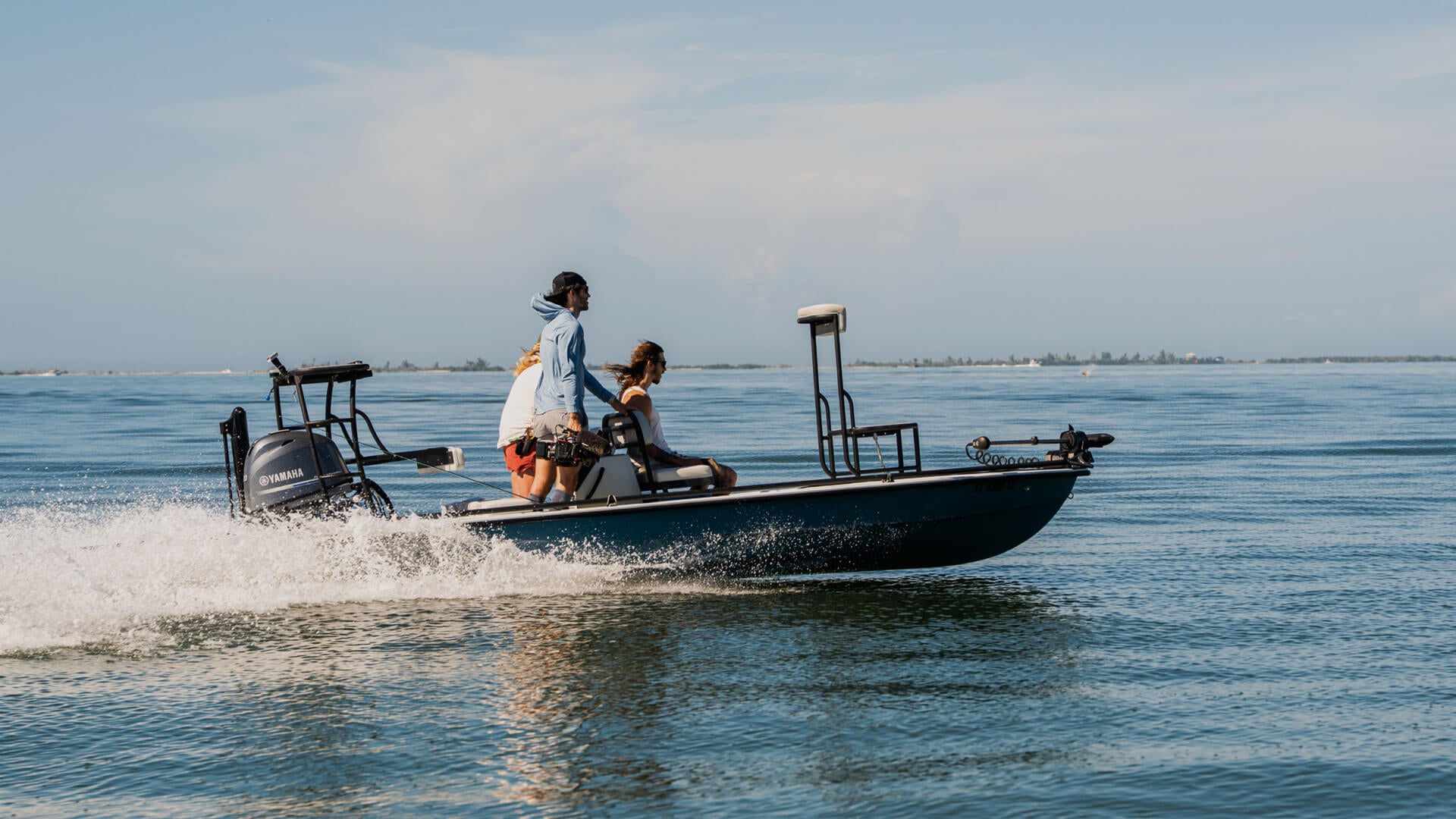 Two people on a boat in the water with a clear sky