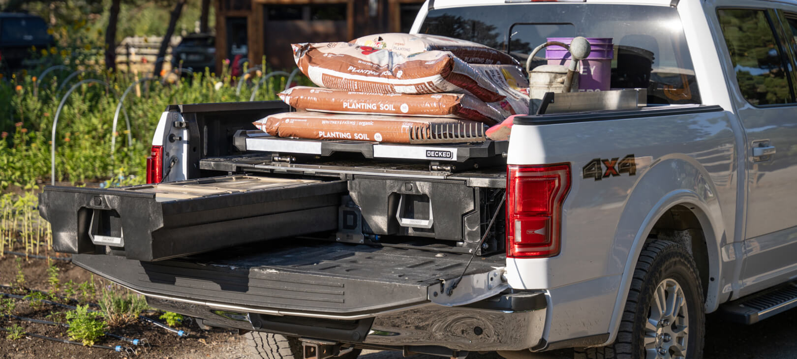 A CargoGlide mounted on a Drawer System piled high with planting soil and other gardening supplies.