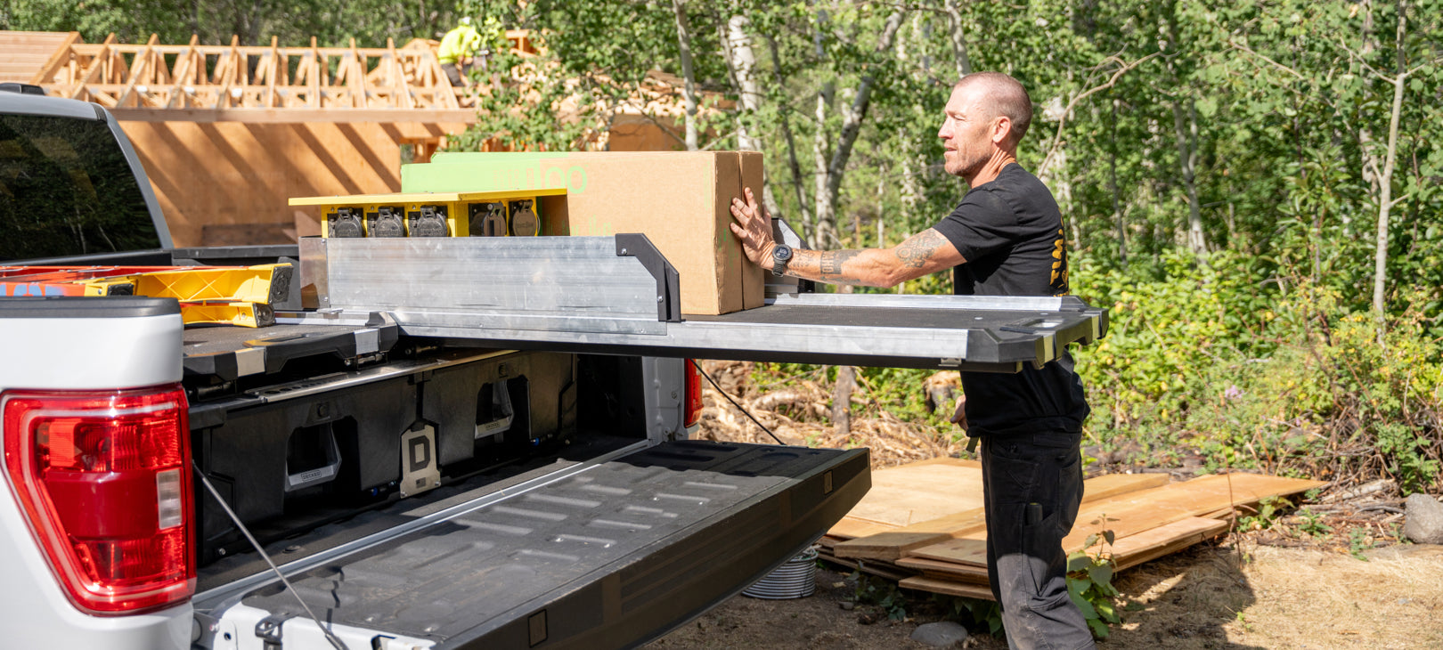 A man loading boxes onto his CargoGlide 600 that is mounted on top of a Drawer System.