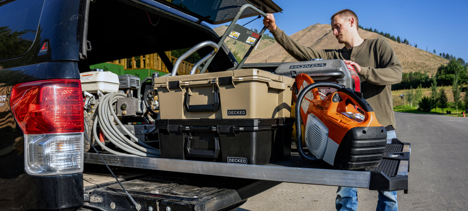 A man retrieving a generator off of his CargoGlide that is full of D-co Cases and other equipment.