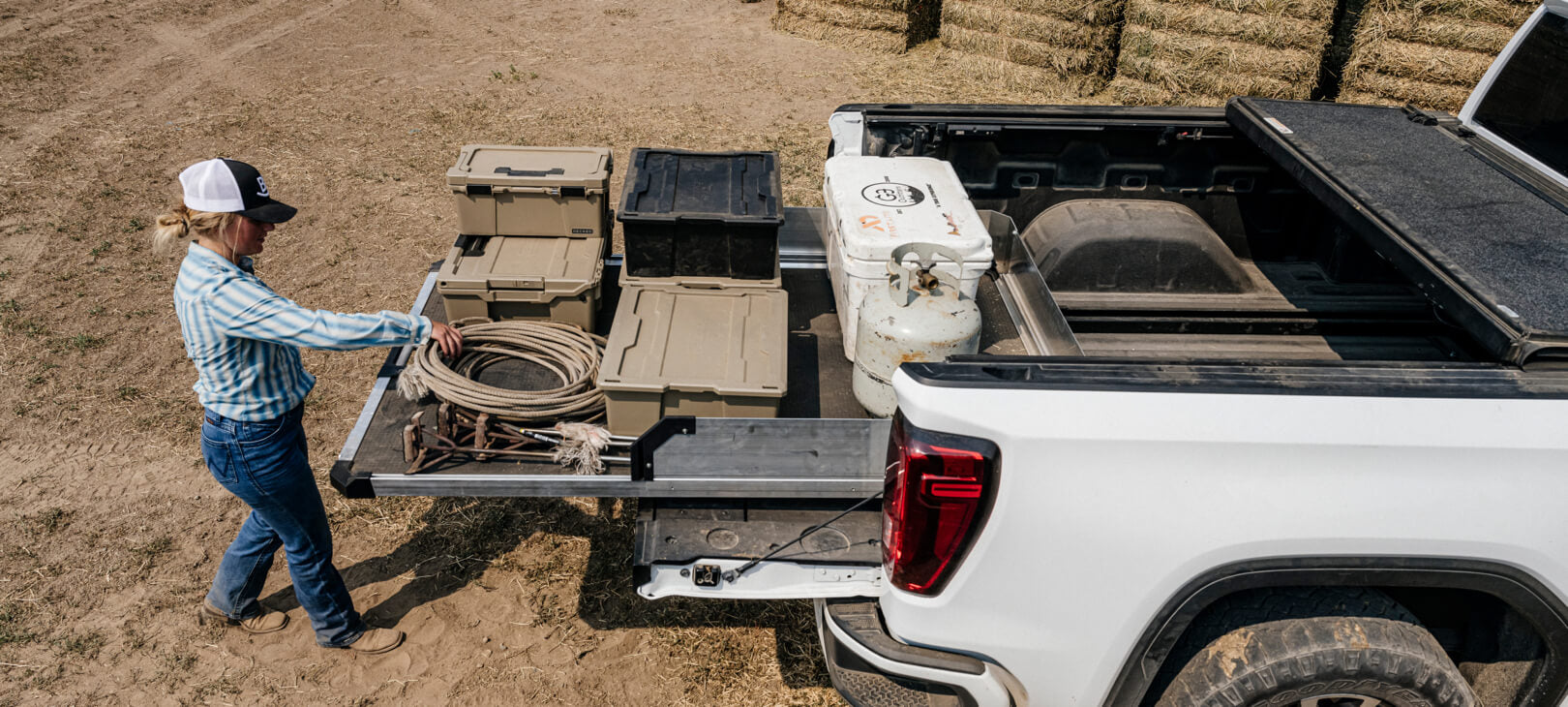 A woman rancher retrieving ropes from her CargoGlide system as she prepares to brand her cattle.