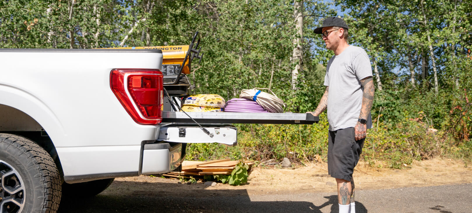 A man extending his CargoGlide 600 loaded with tools, wires and hoses.