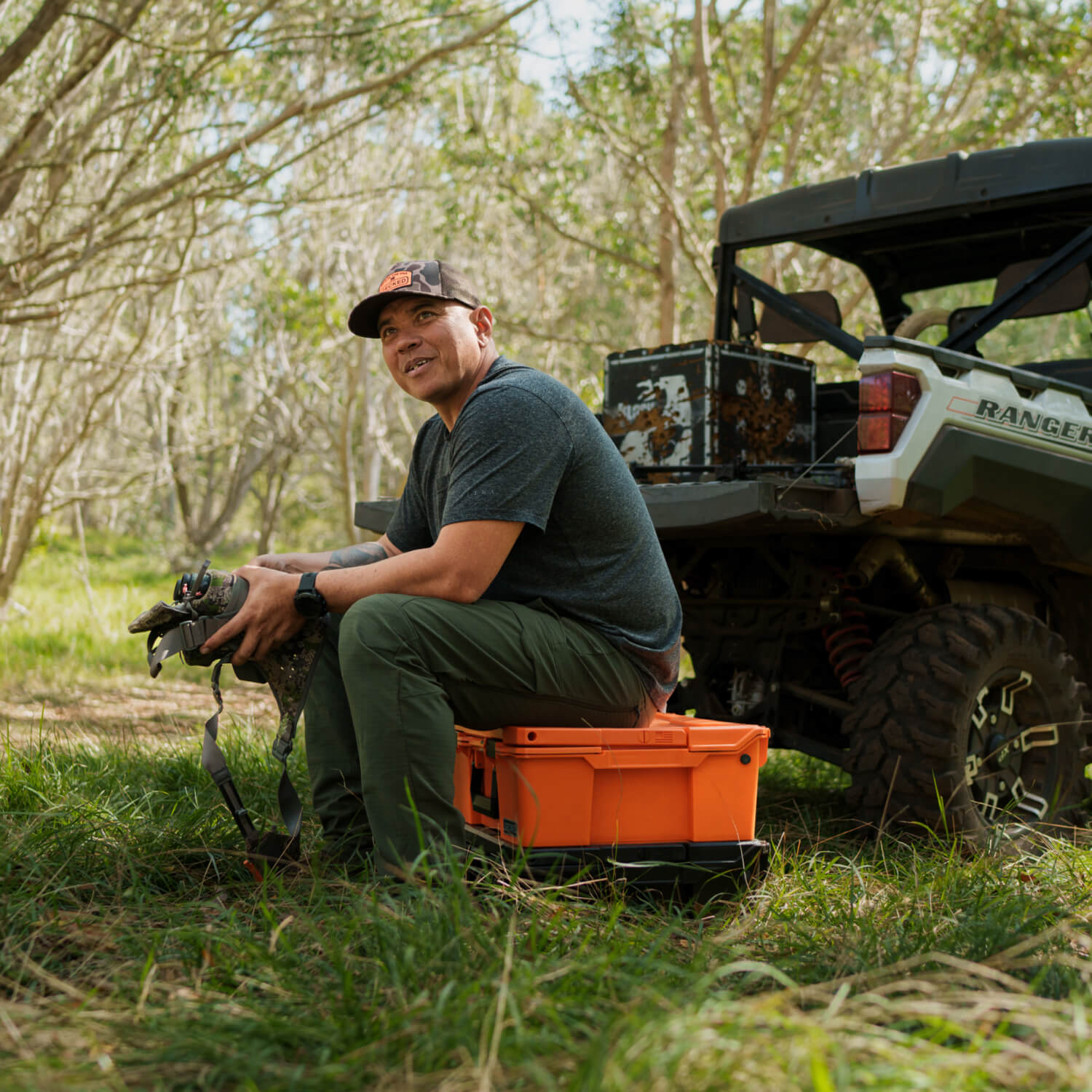 DECKED ambassador, Justin Lee, sitting on his Blaze Orange Halfrack. His side-by-side is in the background.