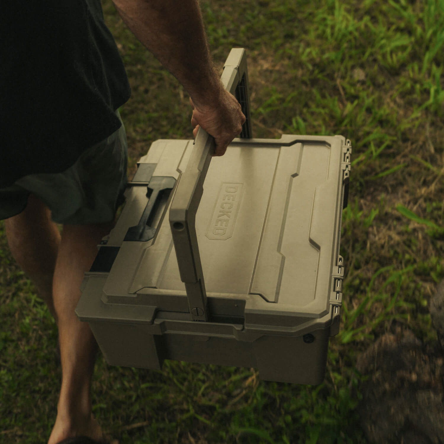 A man carrying the Desert Tan Halfrack by the handle.