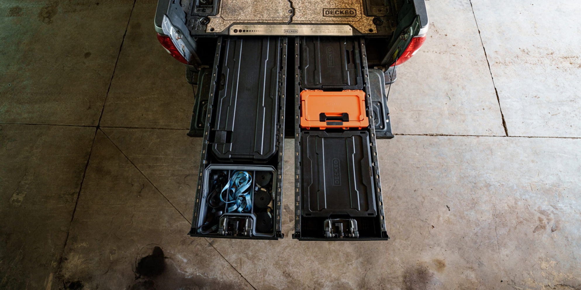 A bird's eye view of an open full-size Drawer System with three black D-co cases surrounding a Blaze Orange Sixer, the orange case pops against the surrounding black cases.