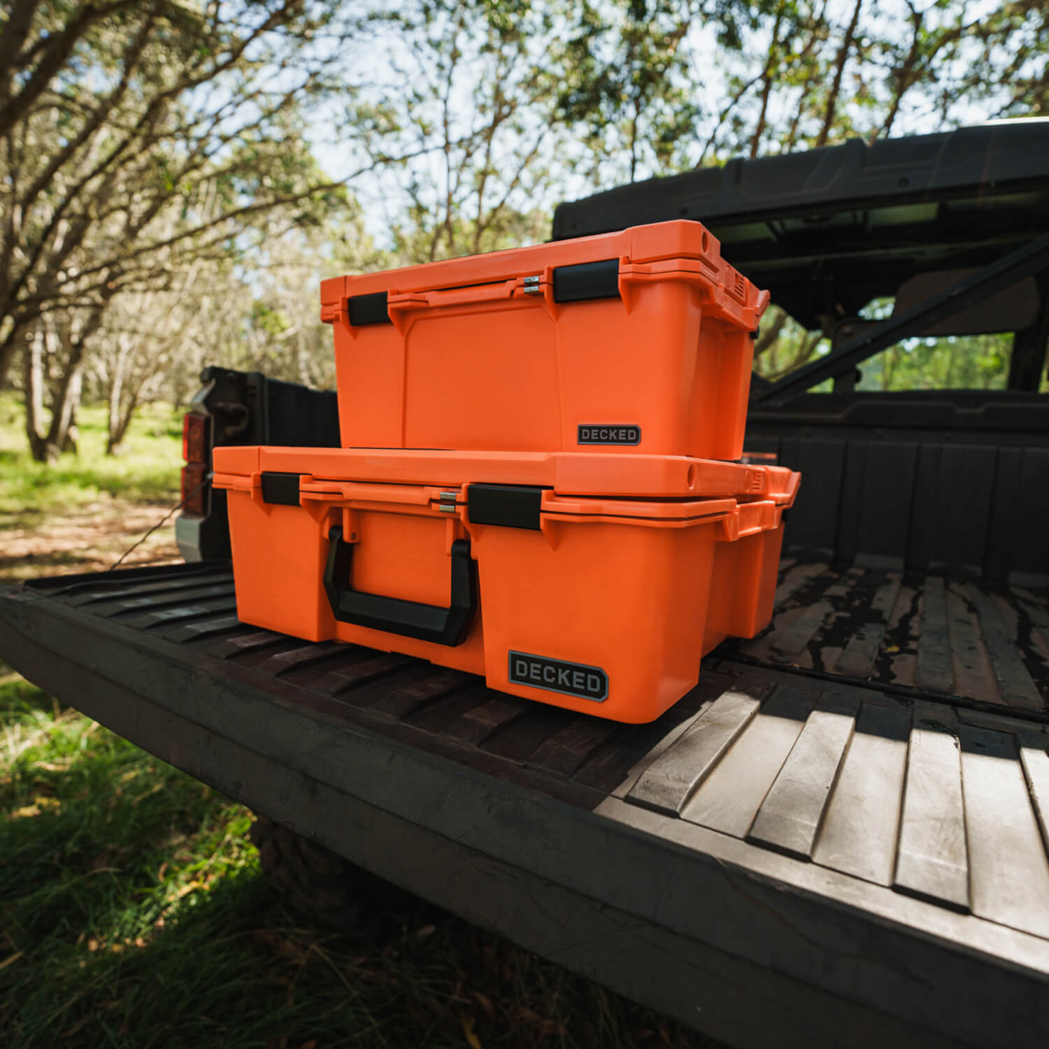 The Blaze Orange Halfrack and Sixer stacked on the tailgate of a side-by-side.