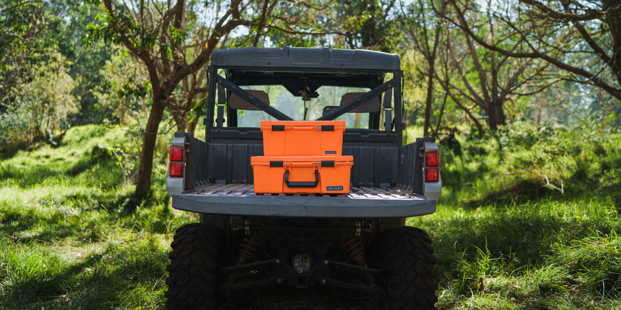 The Blaze Orange Halfrack and Sixer stacked on the tailgate of a side-by-side in the woods.