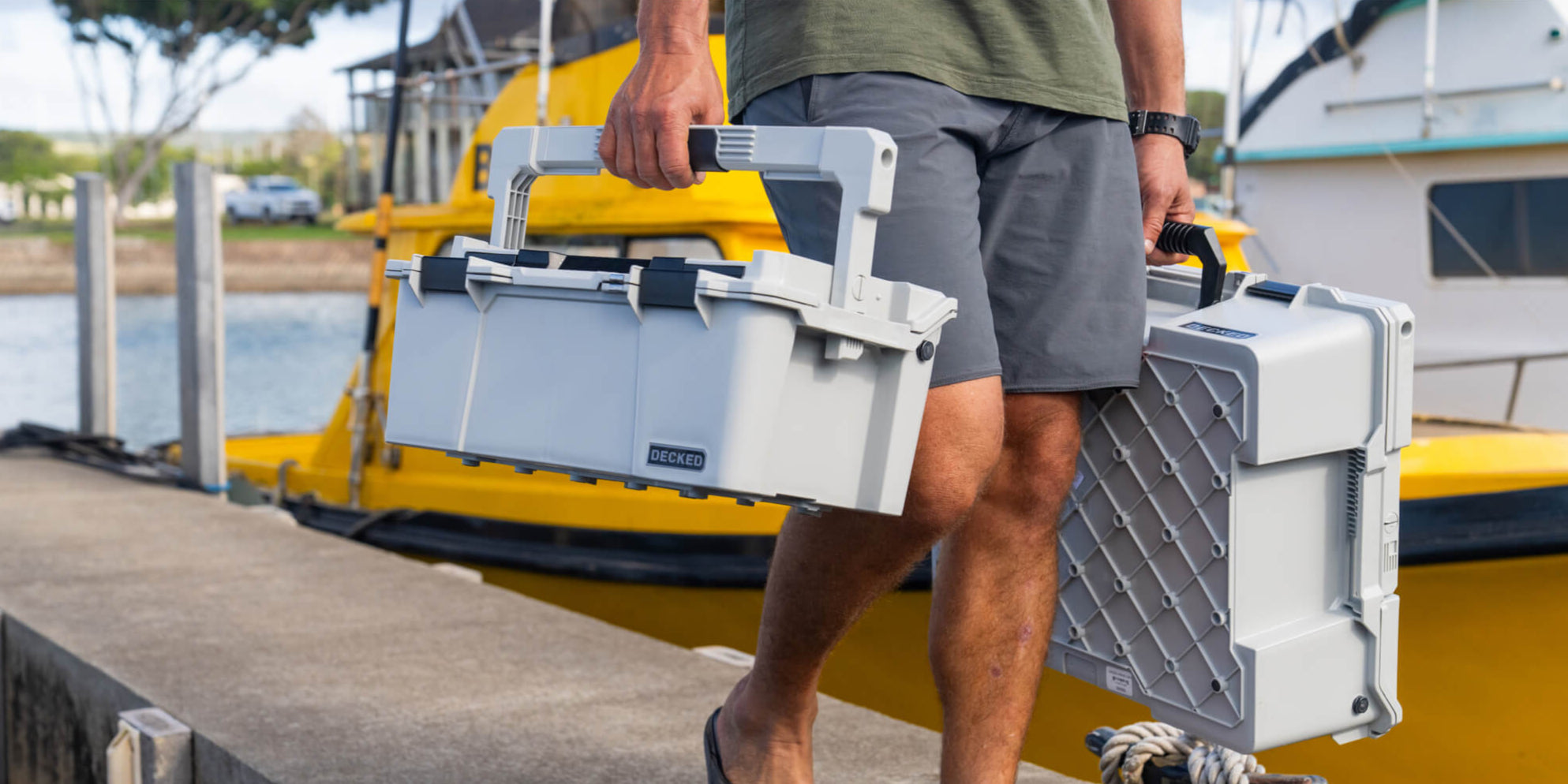 A man walking off the dock in a marina, carrying the Cool Gray Sixer D-co Case which stayed cool to the touch even after sitting in the sun all day.